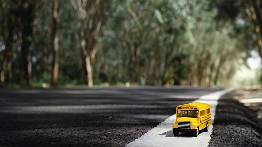 yellow-schookeep child safe at school bus with Devkota law firml-bus-toy-model-country-roadback-schooleducation-concept-background