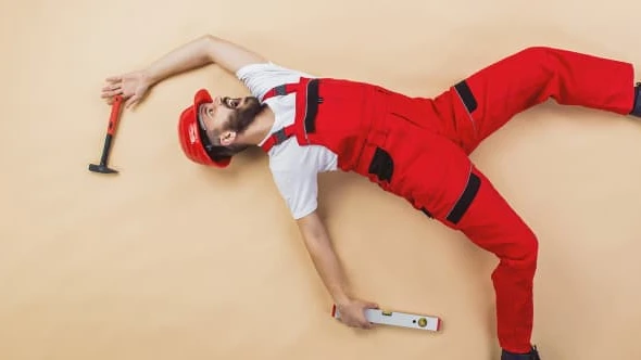 construction-worker-have-an-accident-funny-studio-pose-SBI-305105818